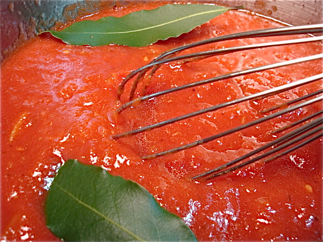Add some ground tomatoes and bay leaves